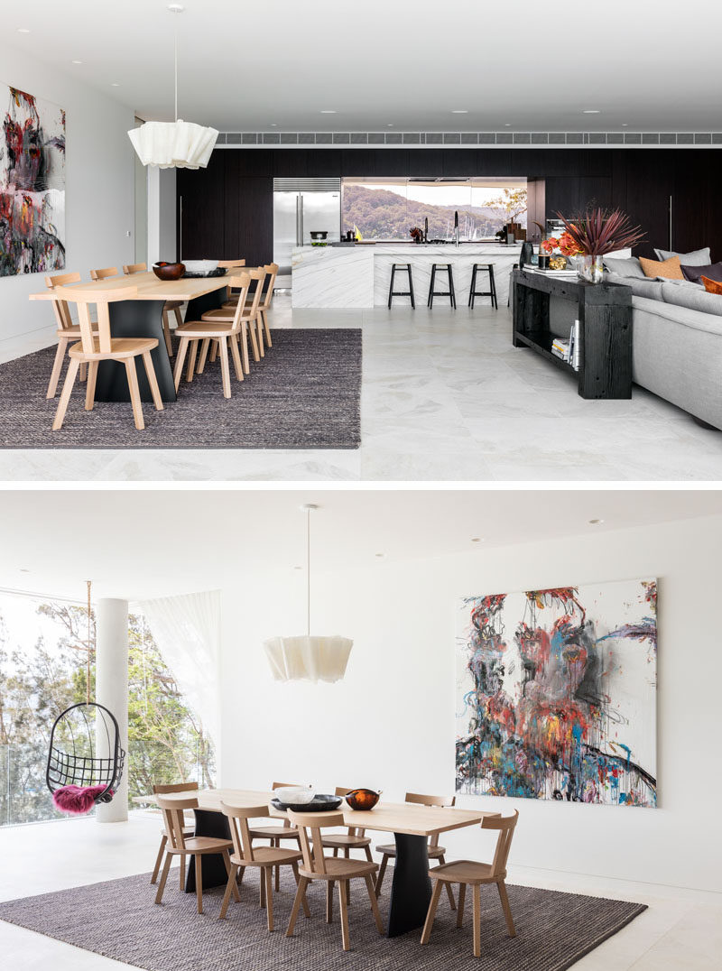 In this open plan interior space, the dining table is anchored by a large rug and single pendant light.  #DiningRoom #OpenPlan #ModernInteriorDesign