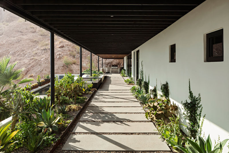 This modern house has a covered patio that's lined with misters to keep the space cool all year round in the desert heat. #Patio #CoveredPatio #Landscaping #Architecture