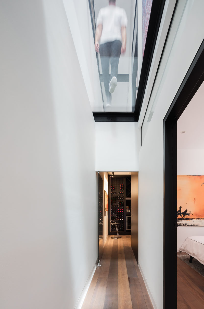 The hallway on the lower level of this modern house takes advantage of the natural light from the skylights and has views of the ridgeline 39 feet (12m) above. #GlassCeiling #GlassFloor #Hallway