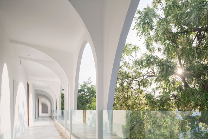 This modern hotel has white arched walkways with glass railings that don't obstruct the view. #HotelDesign #Walkway #GlassRailings