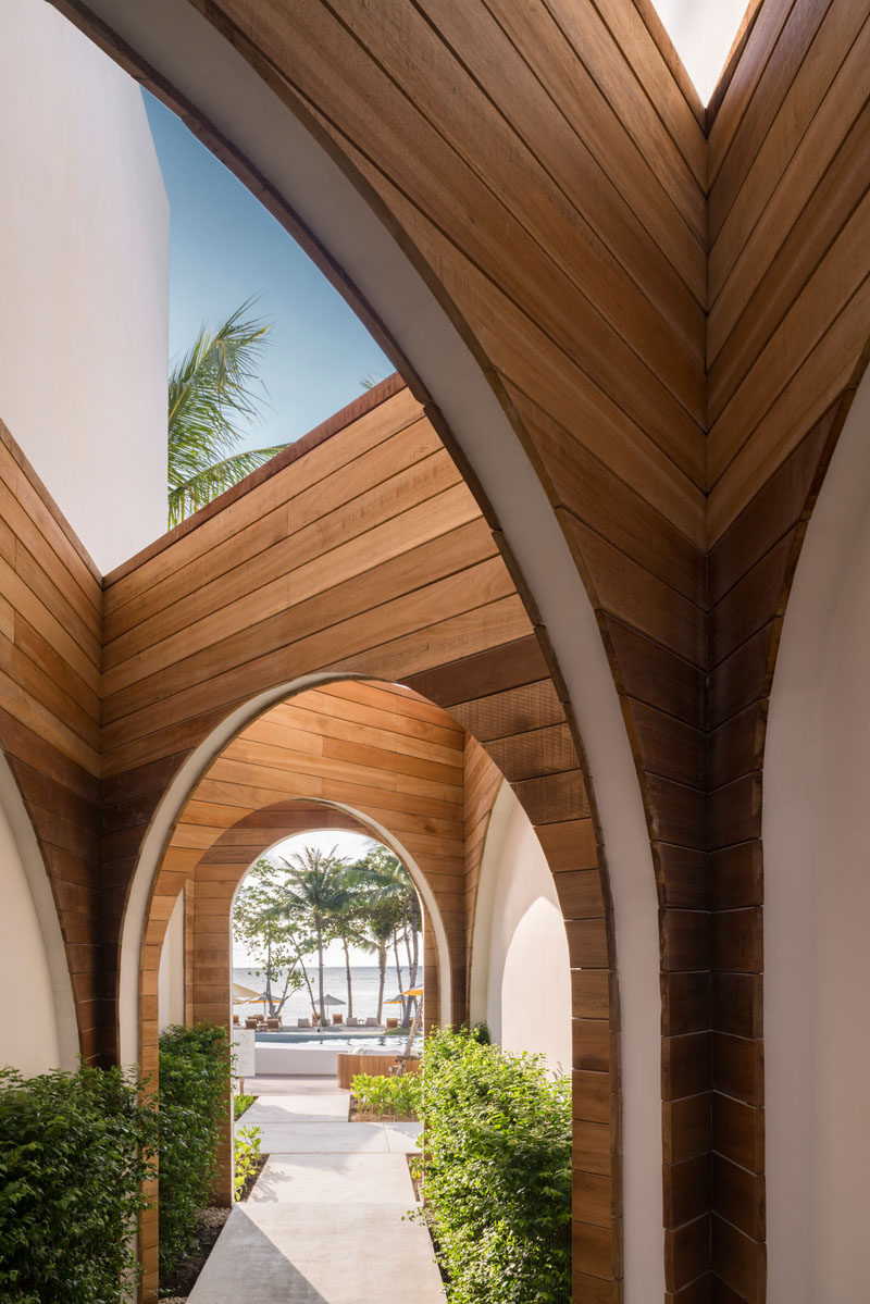 Connecting the various parts of this modern hotel are wood lined walkways that contrast the white exterior of the hotel. #Walkway #Wood #Arches