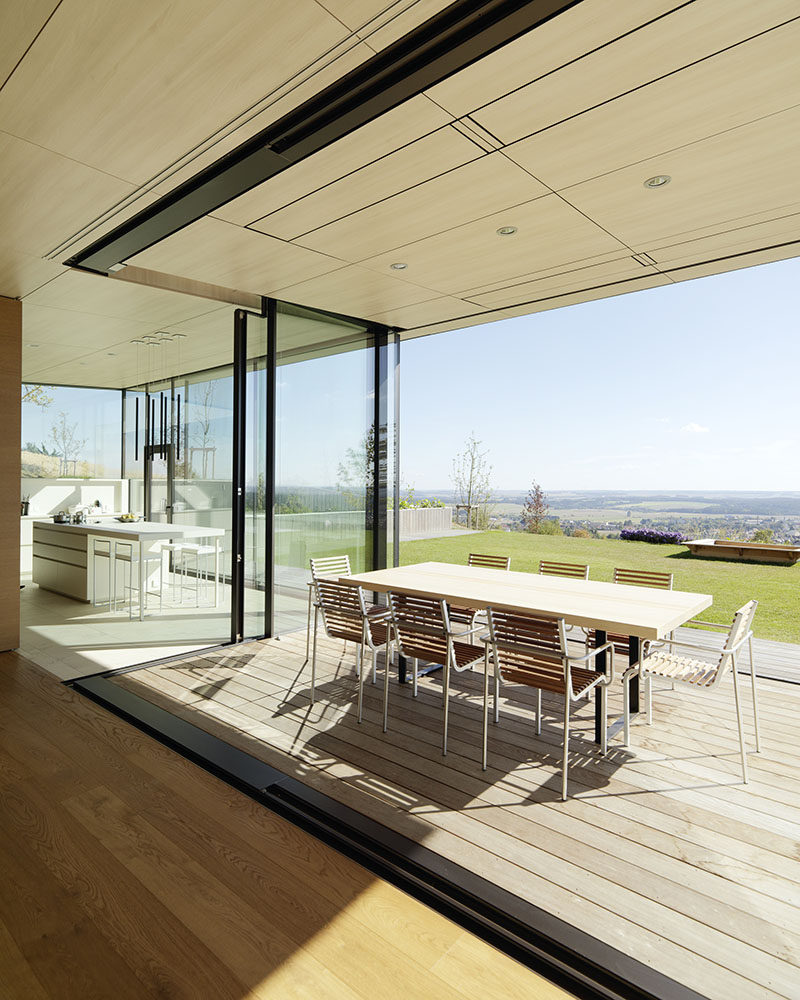 This modern house has an openable glazed corner window arrangement from the kitchen and living space, allows for a semi-outdoor transformation during summer months. #OutdoorDining #GlassWall #IndoorOutdoor