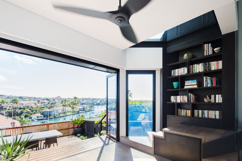 The lower level of this modern house opens up to a spotted gum wood deck set up for outdoor dining, and positioned to take in the Sydney Harbour view. #ModernHouse #WoodDeck #FoldingGlassDoors