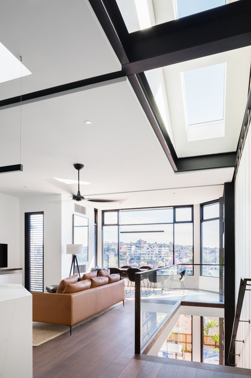 In this modern house, skylights above the stairs filter natural light through to the lower level of the home. #Skylights #ModernInterior #SteelBeams