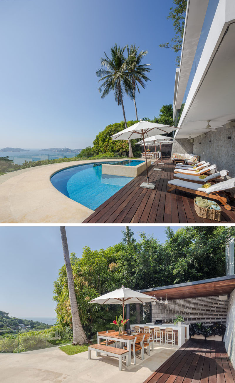 This modern house has a wood deck that provides a place to relax in the sun, a curved pool looking out to the view, and an outdoor kitchen with dining area. #CurvedPool #Deck #OutdoorDiniing #OutdoorKitchen