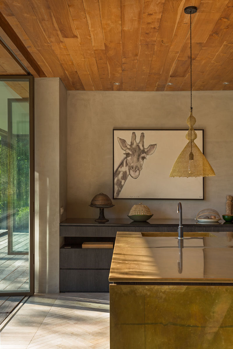 This modern kitchen features a metallic mirrored island and dark wood cabinets. #Kitchen #KitchenDesign #MetallicIsland