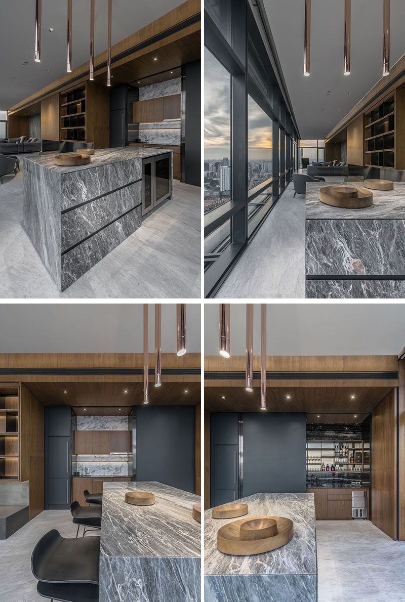 Hidden behind matte black panels in this kitchen area are storage cabinets and a full bar. #Kitchen #Bar #Stone