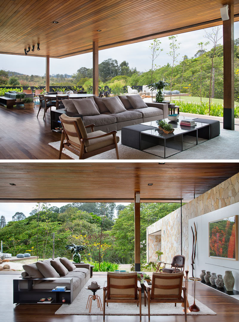 Through the use of sliding glass walls, the designers of the house were able to bring nature to the living areas. The open plan room has a multiple seating area, a dining area, and a kitchen. #IndoorOutdoor #WoodCeiling #Architecture #LivingRoom