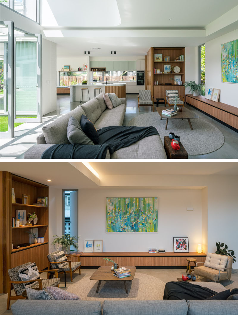 In this contemporary living room, custom wood details have been designed to run along the wall, while a wood display cabinet with storage has been built into the wall. #LivingRoom #WoodCabinetry