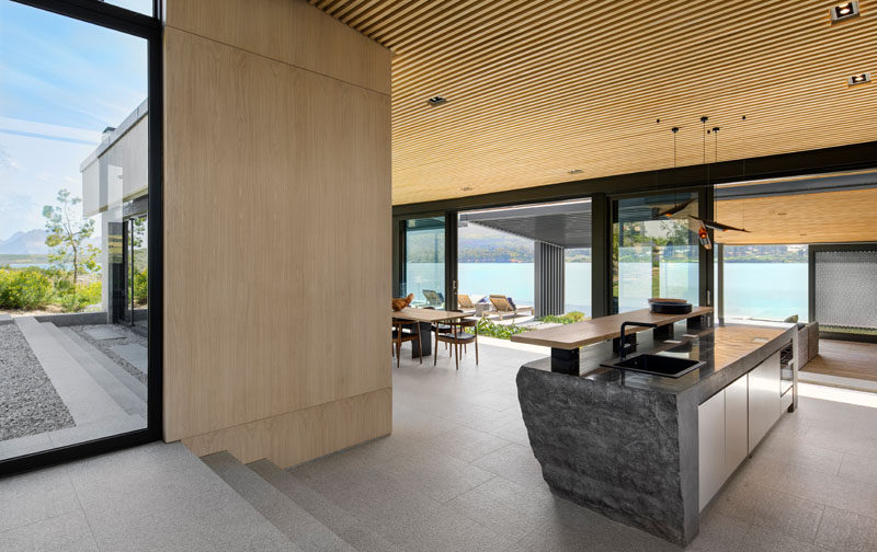 The kitchen island in this modern house has been created using rough solid blocks of granite, with a highly polished top that serves as the counter. #Granite #GraniteIsland #RoughGranite