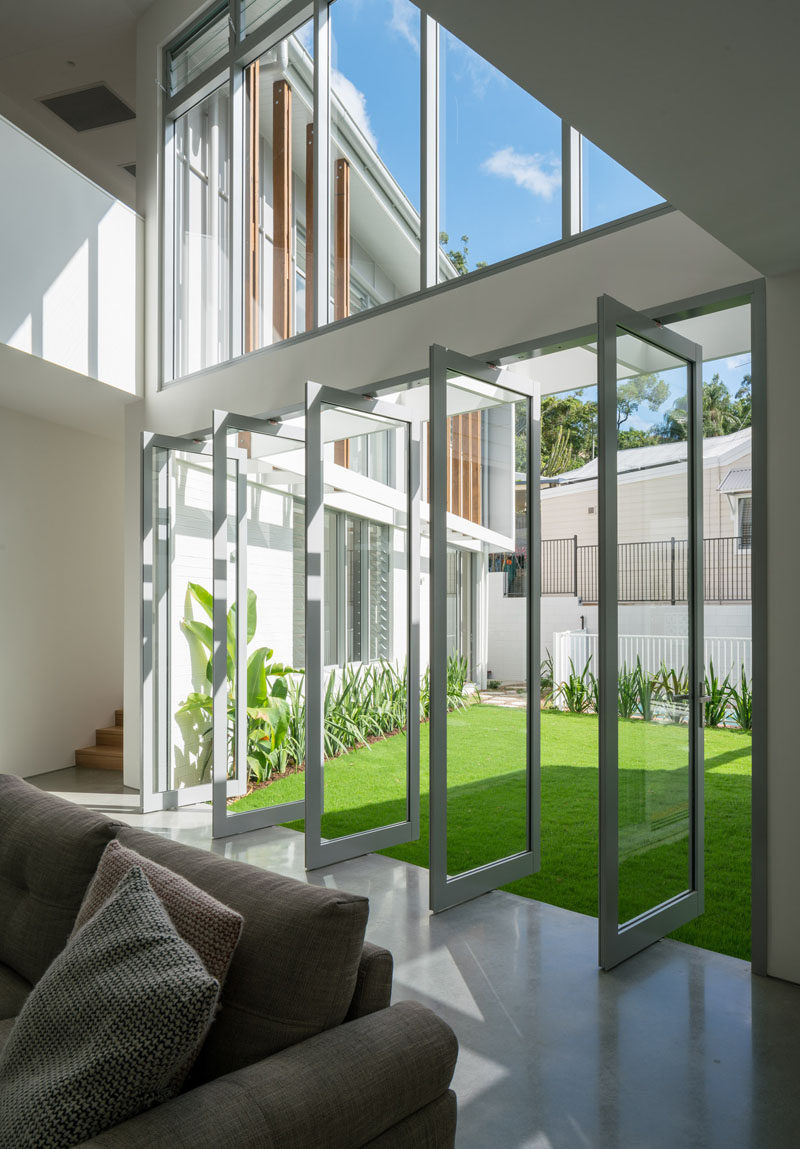 This contemporary house has pivoting glass windows that connect the courtyard and the living room. #PivotingWindows #PivotingDoors #Windows #Doors