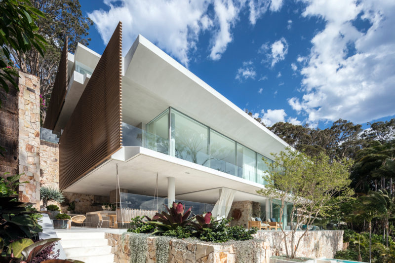 Koichi Takada Architects have designed a new house in Sydney, Australia, that sits on a steeply sloping waterfront lot, and features sandstone walls and expansive water views. #ModernHouse #Architecture #HouseDesign