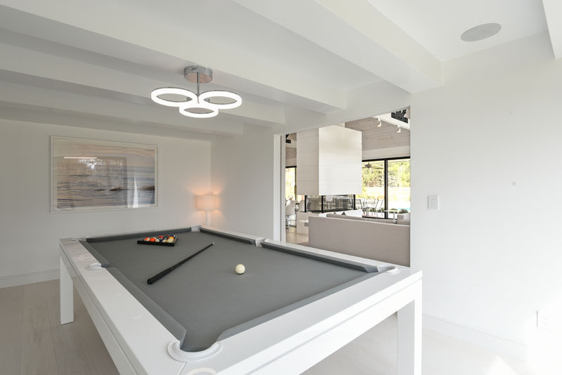 In this modern games room, there's a minimalist white pool table with a grey surface. #PoolTable #ModernGamesRoom