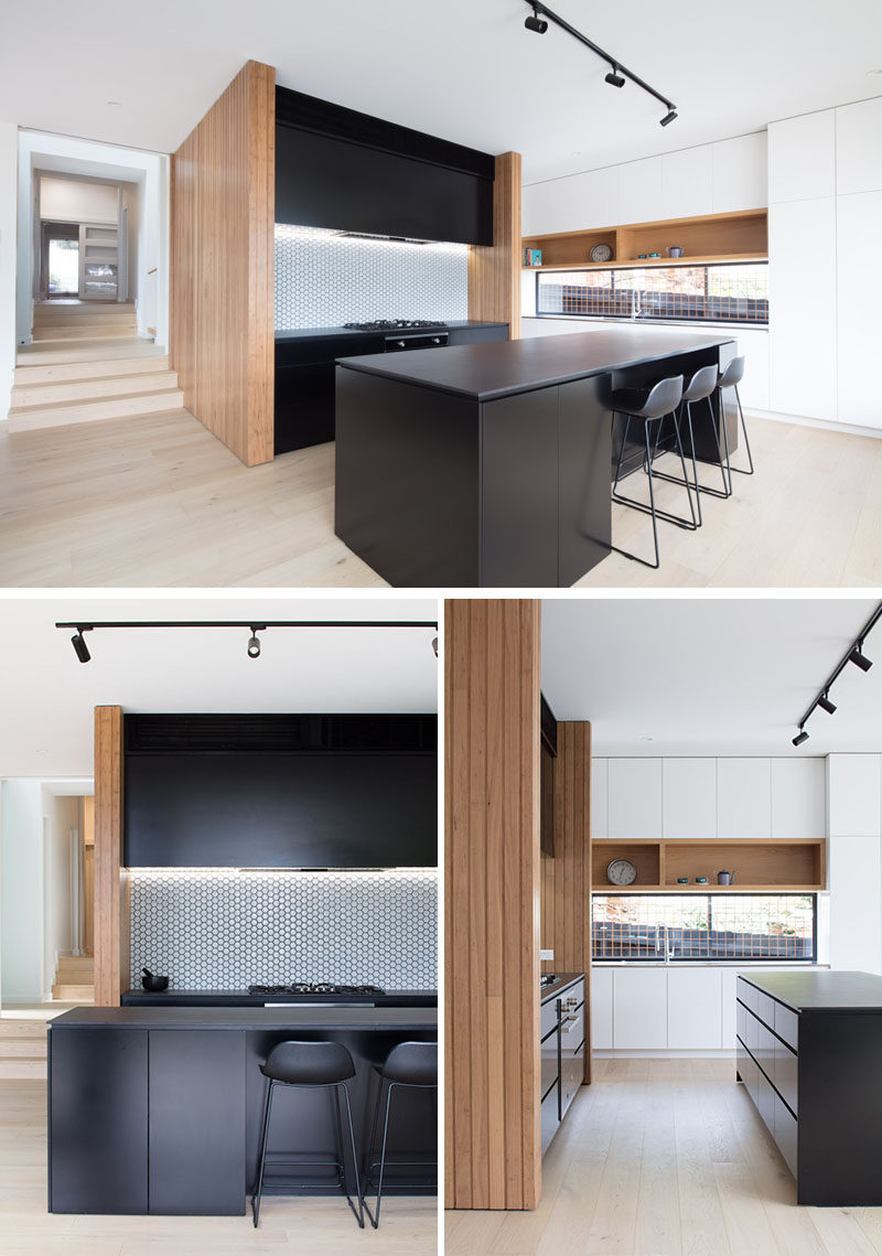 In this modern kitchen, a black island and black cabinets strongly contrast the wood elements, while white cabinets feature on the adjacent wall. #ModernKitchen #BlackKitchen #KitchenDesgin