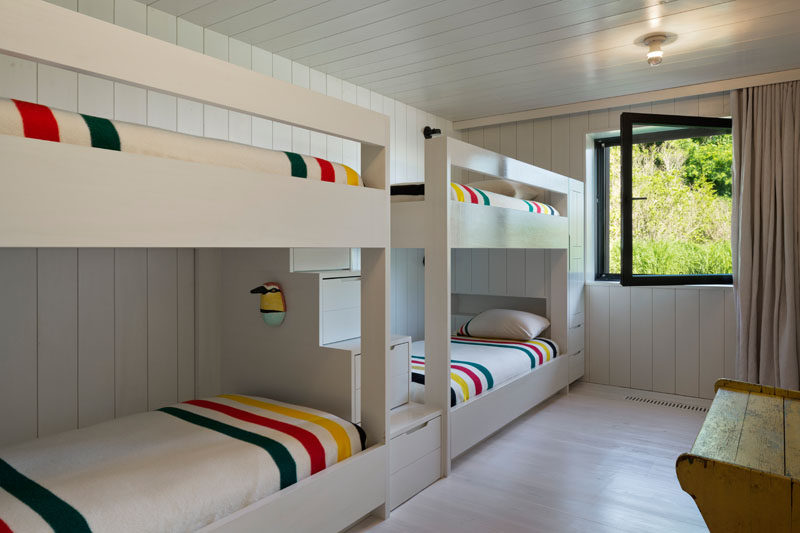 This bunkroom has been designed to run the multiple bunk beds alongside one wall, with a set of stairs with storage between them. #BunkBeds #Bunkroom #Bedroom