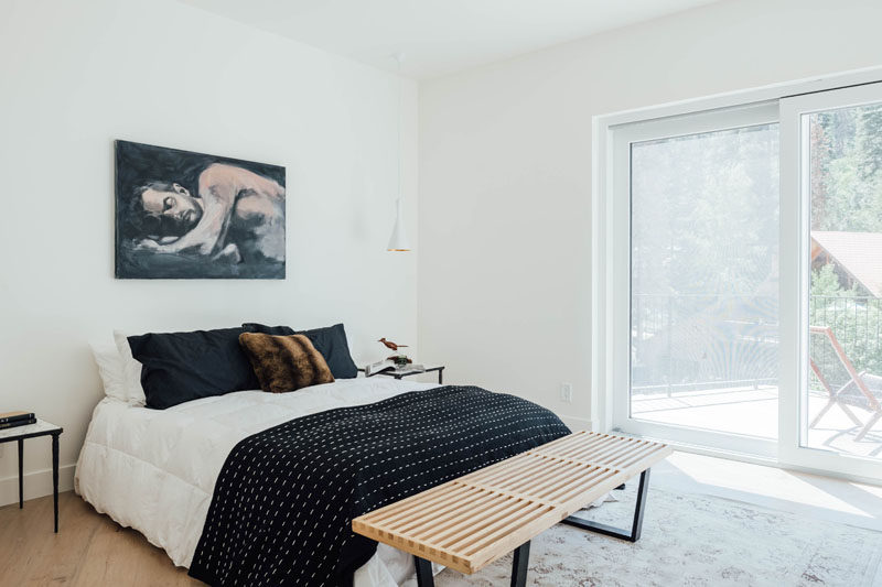 In this contemporary bedroom, the furnishings have been kept minimal, and a sliding door opens to a private deck with views of the trees. #BedroomDesign #ModernBedroom