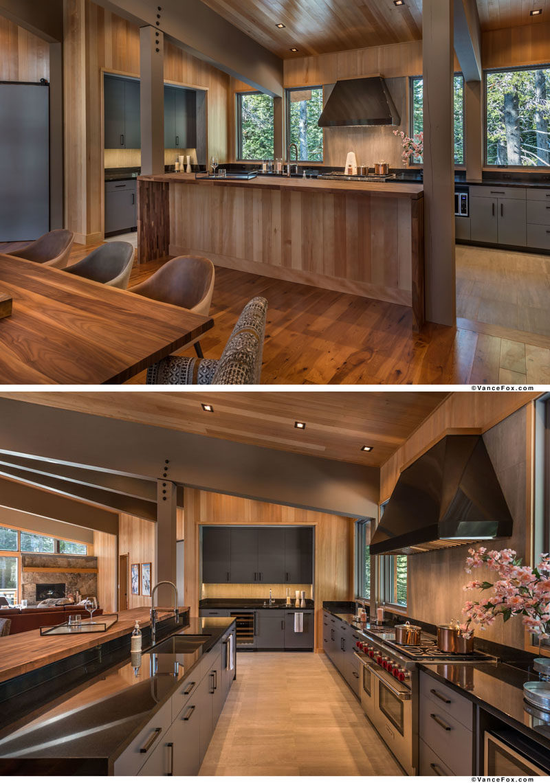 This contemporary mountain cabin kitchen features an island with waterfall slab countertops, grey cabinets, and premium appliances. #ModernKitchen #KitchenDesign