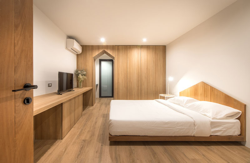 In this modern and minimalist bedroom, gabled design elements have been included in the door frame and the headboard. #Bedroom