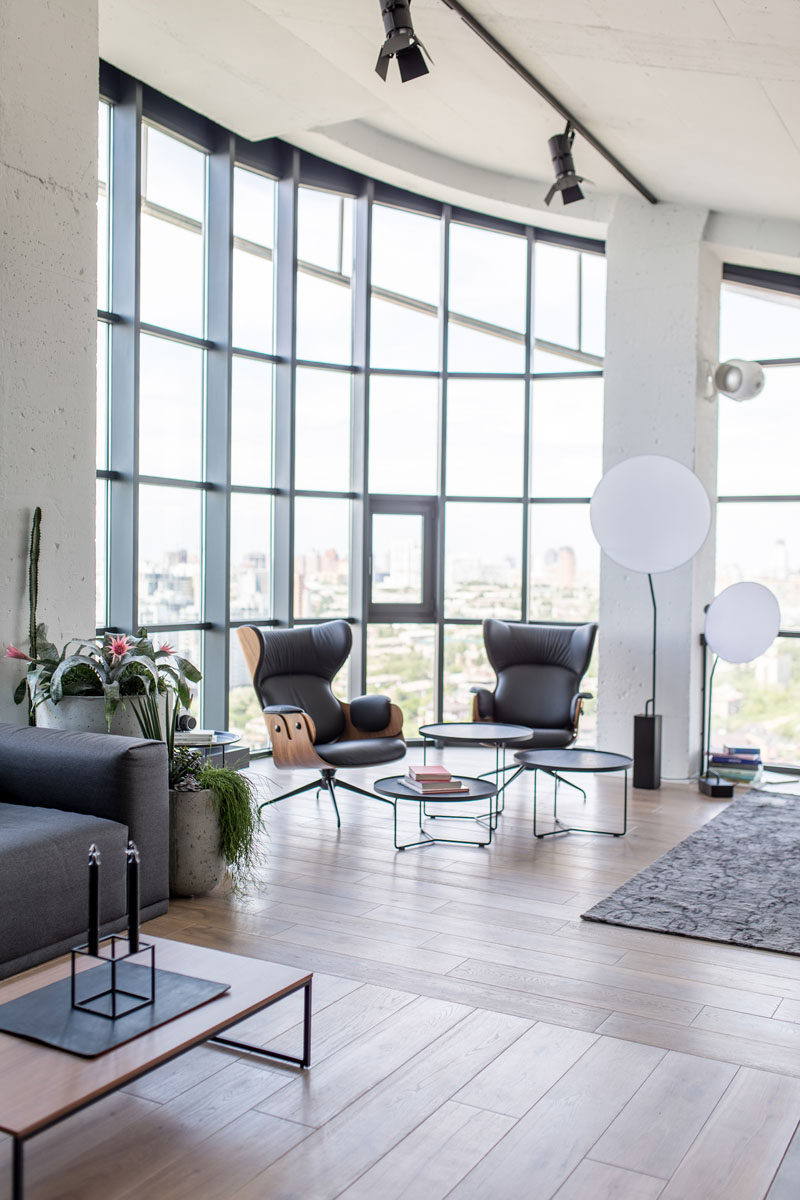 Materials like, wood, concrete, glass, and stainless steel have been used to create a industrial modern interior for this penthouse apartment. #IndustrialModern #Apartment #Windows #Penthouse