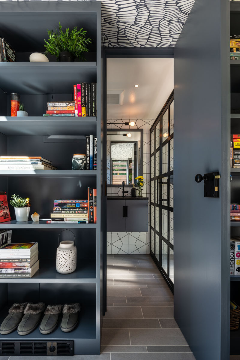 In this small backyard studio, there's a door surrounded by bookshelves that leads to a bathroom. #Bathroom #Shelving #BackyardStudio