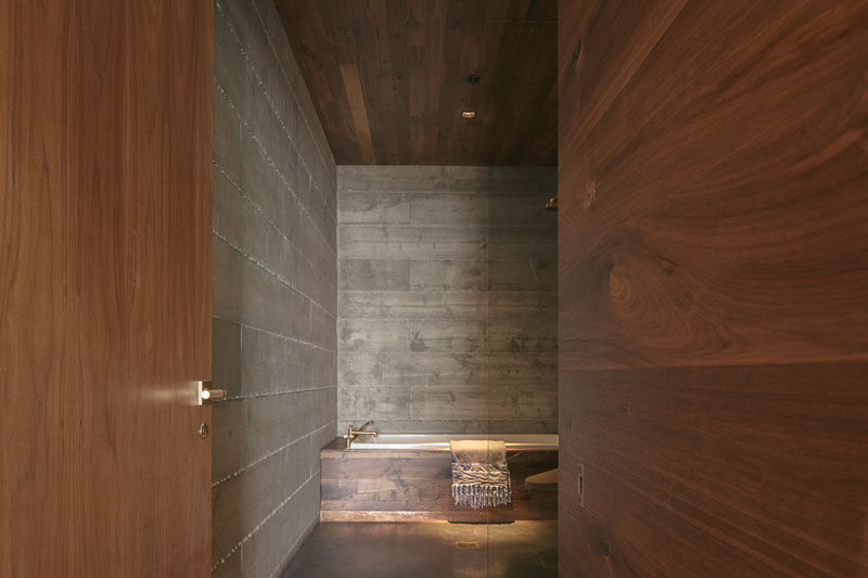 This modern bathroom has a material palette of concrete and rich walnut. #Bathroom #BathroomDesign #ModernBathroom