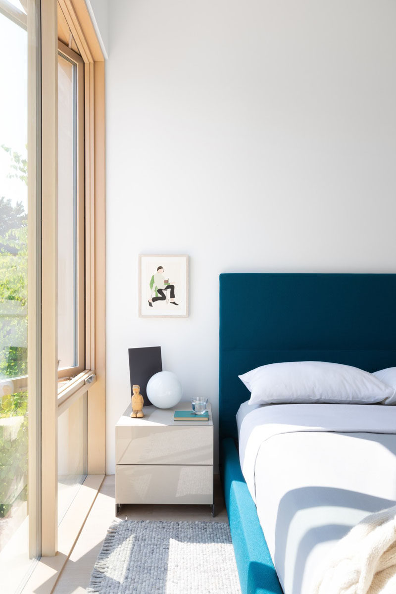 In this contemporary guest bedroom, the furnishings have been kept simple, with a blue bed frame adding some color. #GuestRoom #BedroomDesign