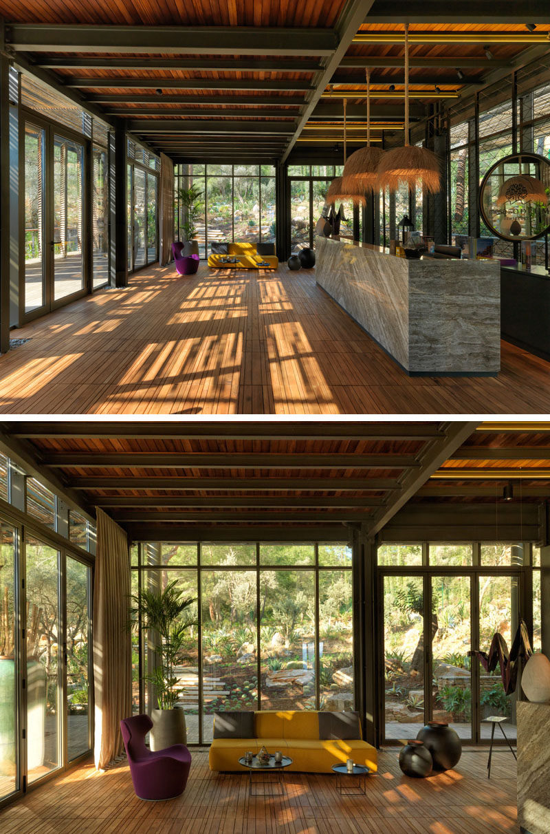 Inside this modern club house, there's a reception area with floor to ceiling glass walls that provide views of the trees. #ClubHouse #Reception #Lobby #Windows