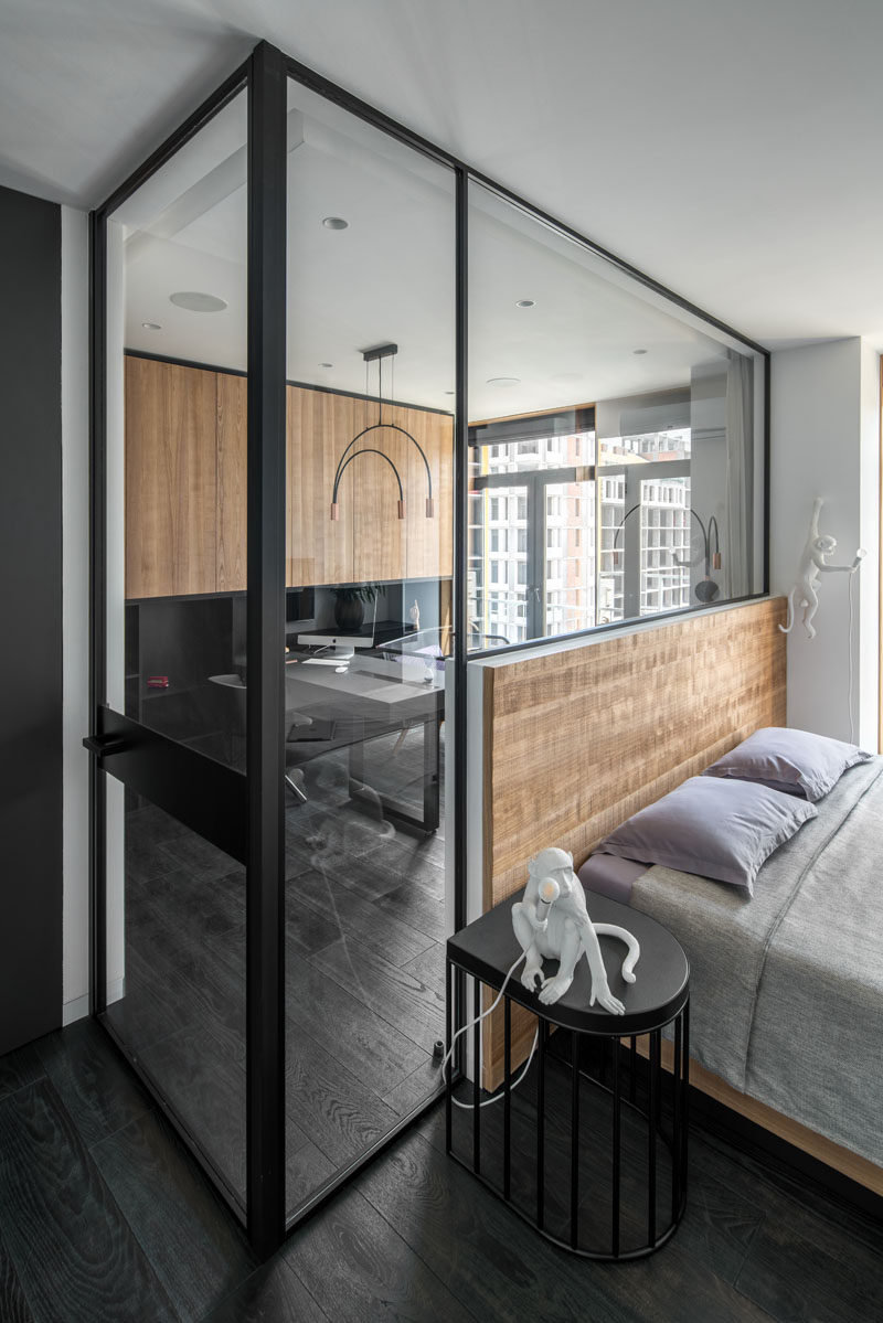 In this modern bedroom, a glass partition has been used to separate the home office from the sleeping area. #ModernBedroom #GlassPartition #HomeOffice