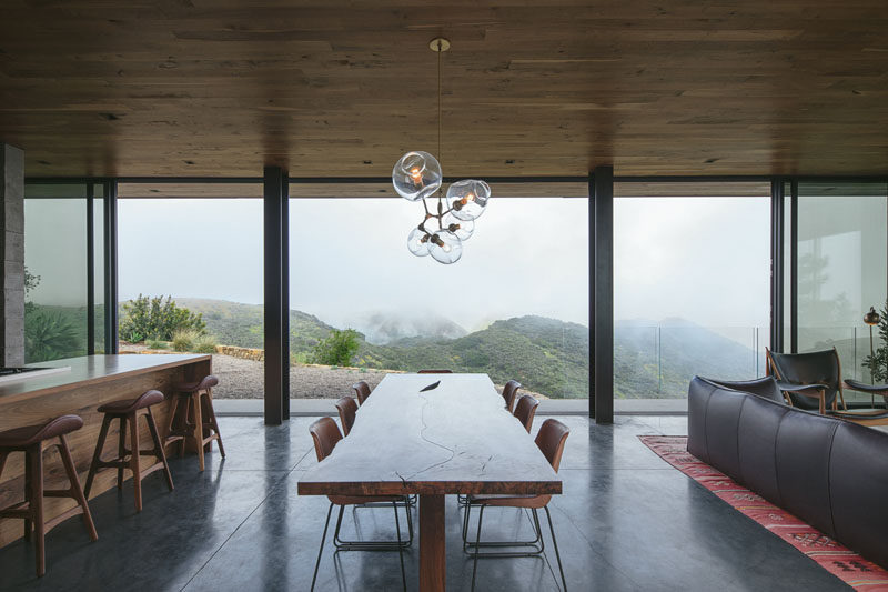 This modern guest house has sliding glass walls that open up the dining area to a balcony and outdoor space. #DiningRoom #GlassWalls #InteriorDesign