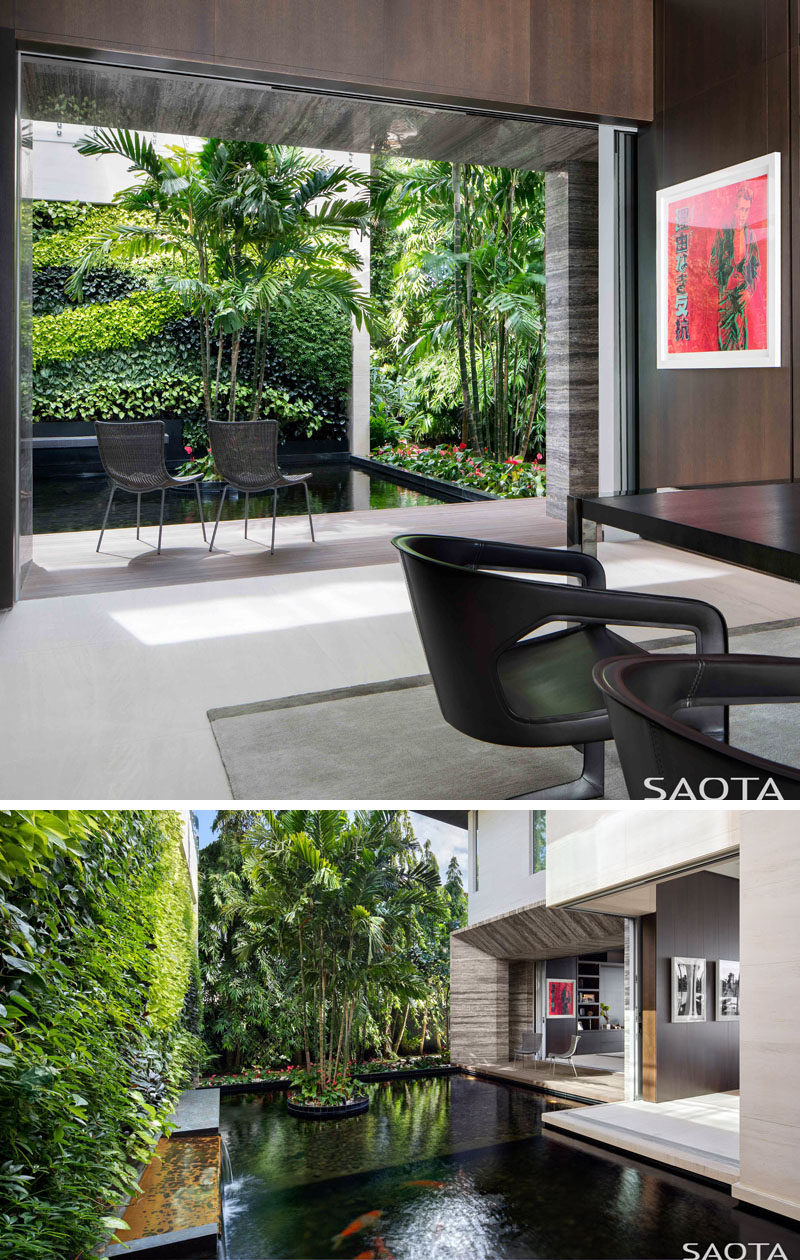 This modern home office has sliding doors that open to a water feature and green wall. #HomeOffice #WaterFeature #GreenWall