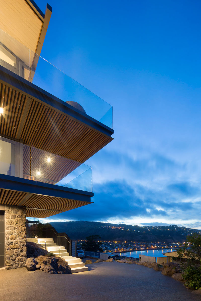 Tucked away behind the stone faced facade of this modern house is the basement that houses a double garage with storage. #ModernHouse #Driveway #Architecture