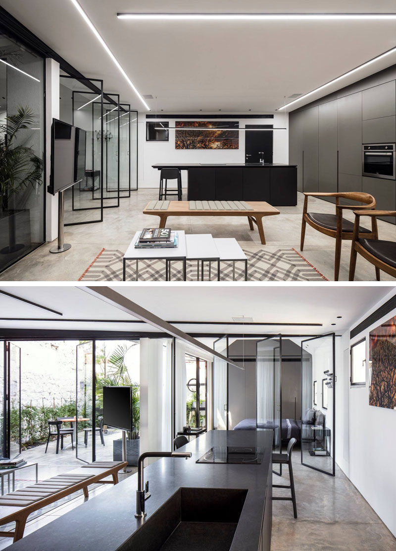 The black island in the kitchen was designed to create a focal point in this modern interior that has polished concrete floors. #ModernKitchen #BlackIsland #ConcreteFloors