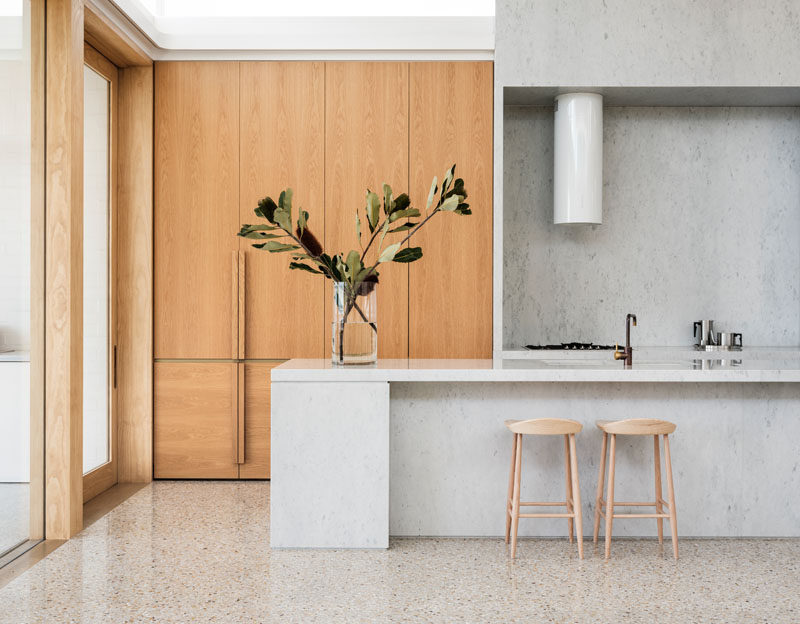 This modern wood and grey kitchen runs alongside one wall of an open plan interior. #Kitchen #KitchenDesign #ModernKitchen