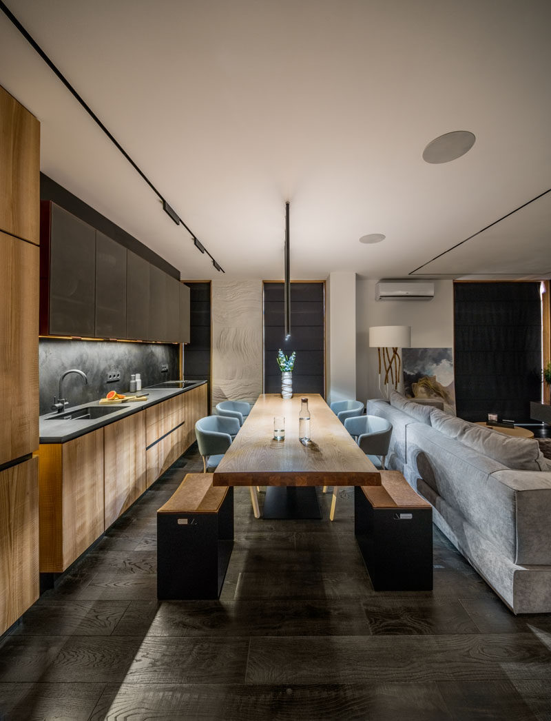 In this modern kitchen, a wood table surrounded by seating creates a place for food prep and family meals, while wood and copper kitchen cabinets run along the wall. #DiningRoom #Kitchen #ModernKitchen #InteriorDesign