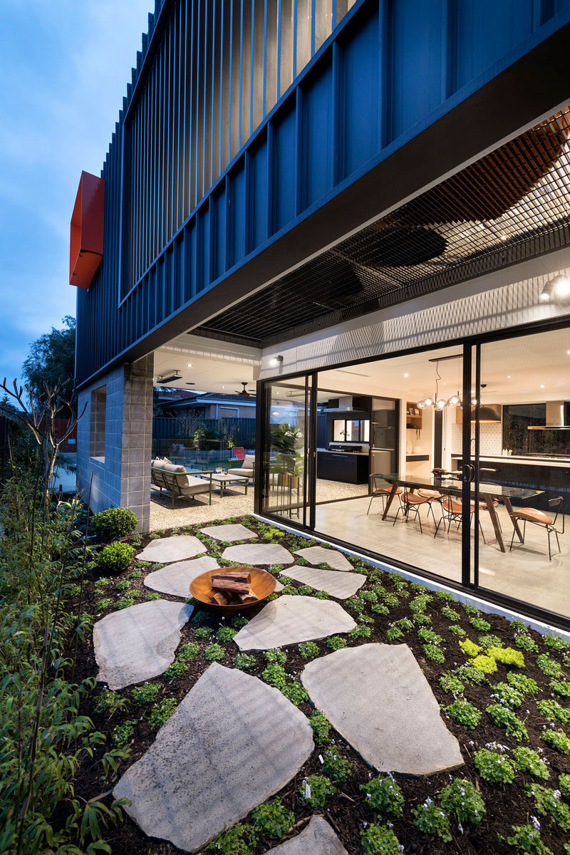 This modern house has a side garden with a small firebowl, that can be accessed from the covered outdoor lounge, or the dining room inside. #SideGarden #Firebowl #ModernHouse #Landscaping