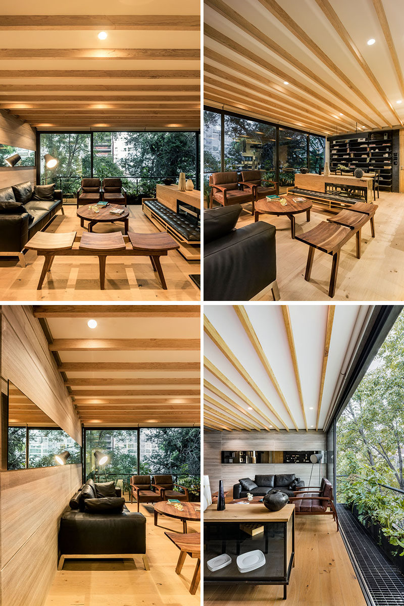 In this modern living room, multiple seating designs surround a round wood coffee table, and a sliding glass door opens the interior to a small balcony. #LivingRoom #ModernLivingRoom