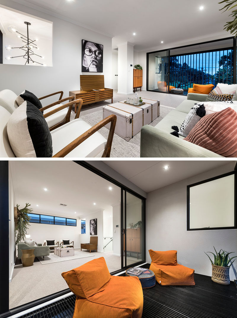 This modern family room opens up to a somewhat enclosed balcony that looks over the street below. #FamilyRoom #LivingRoom #Balcony