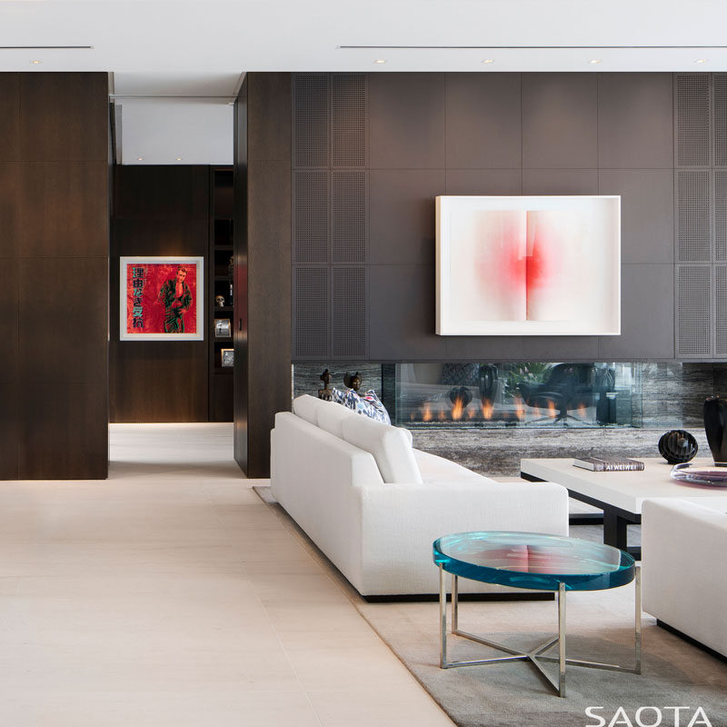 Inside this modern house, high ceilings have been combined with dark wood joinery, and in the living room, a horizontal fireplace has been added with a stone hearth. #ModernInterior #Fireplace #LivingRoom