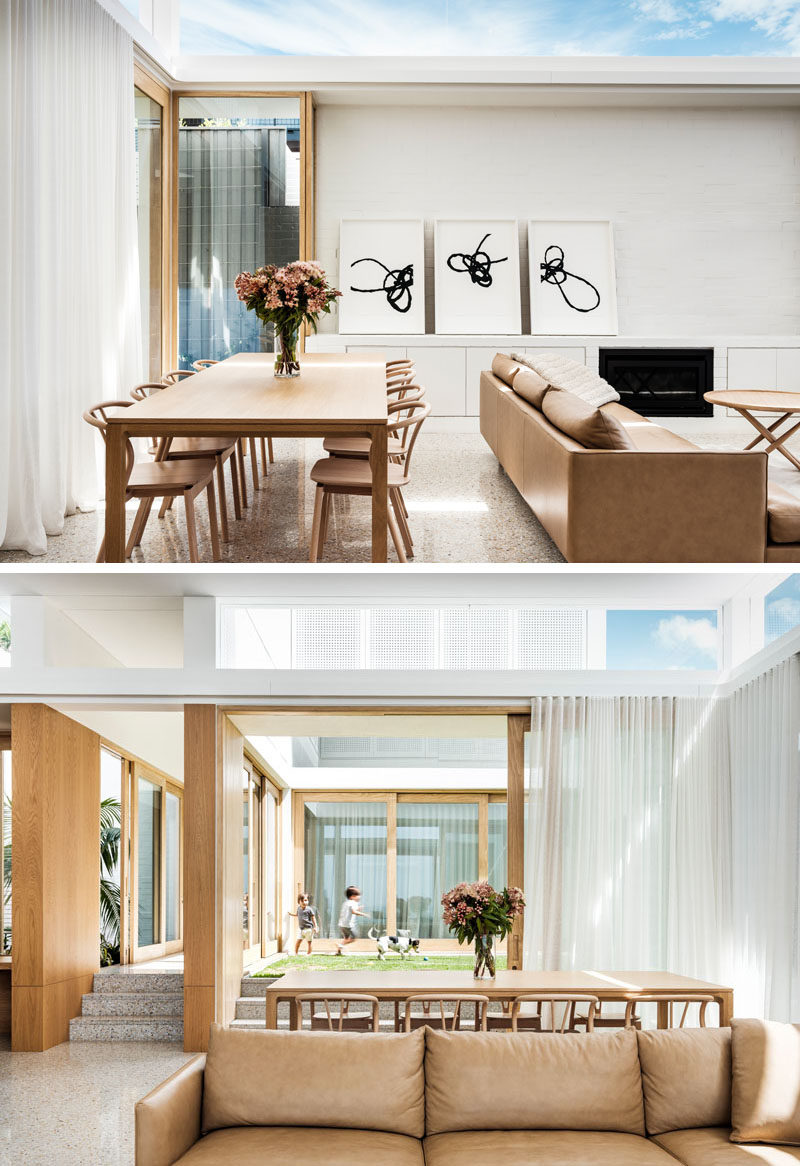 The dining area of this modern house has sliding wood-framed glass doors that open up to a grassy courtyard. #DiningRoom #ModernInteriors