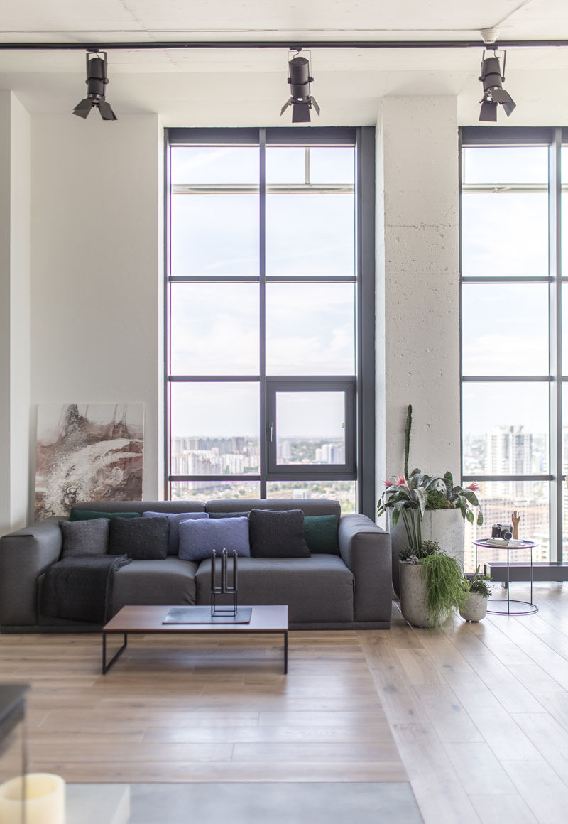 Tall ceilings and metal window frames are featured throughout the apartment that has an industrial modern theme. #ModernIndustrial #LivingRoom #InteriorDesign #Windows