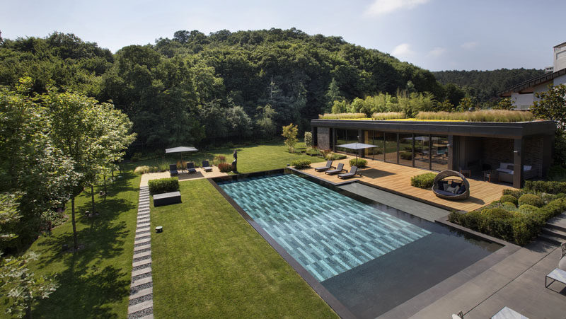 This modern poolhouse, which has a green roof, has been designed to accommodate a living space, kitchenette, outdoor lounge, gym, changing room and toilet. #Poolhouse #SwimmingPool #GreenRoof #Architecture #Landscaping