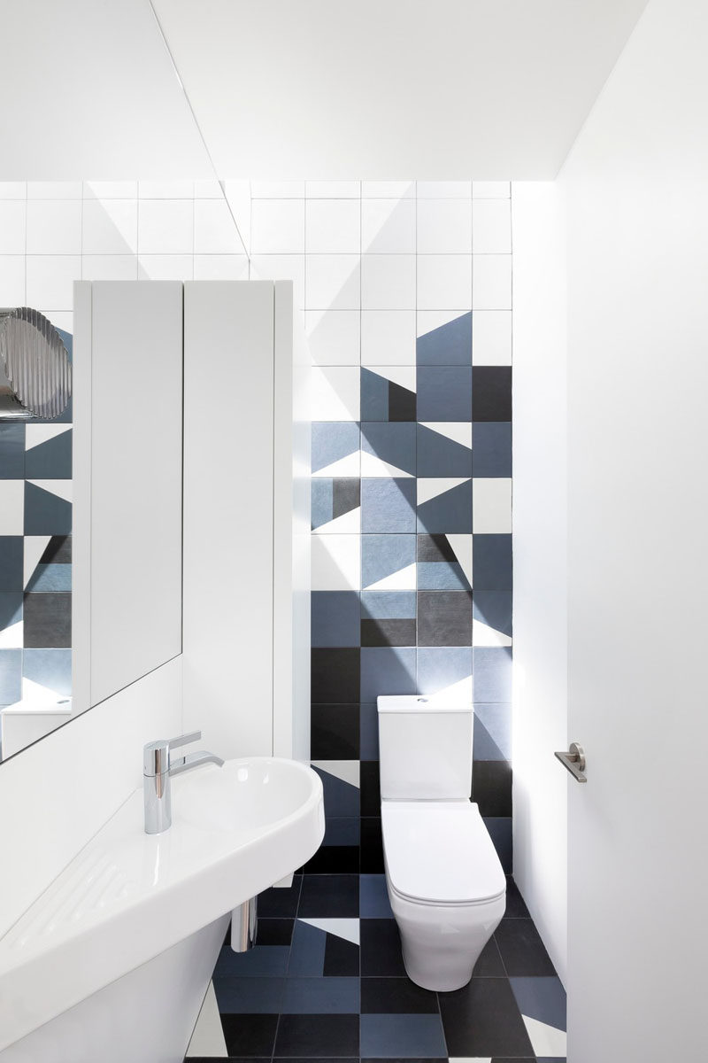 This modern powder room has bold geometric tiles in blue and black.. #ModernBathroom #PowderRoom