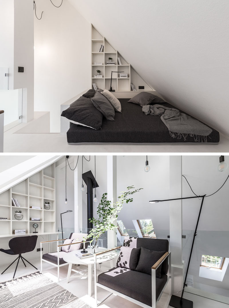 This modern home office, built within an attic, has a bookshelf that follows the roof line, and a mattress on the ground creates a relaxing spot to read a book. There's also a couple of armchairs and a desk area with additional shelving. #HomeOffice #Attic #ModernInteriorDesign