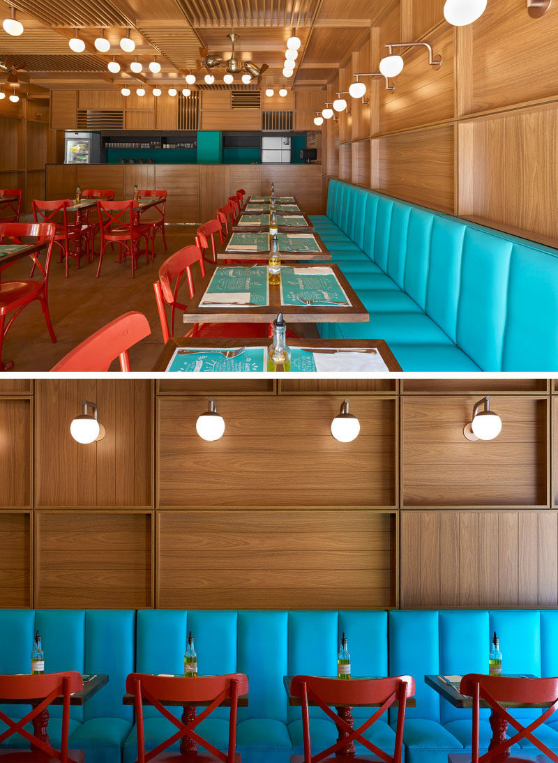 To add some color to the mostly wood interior of this modern restaurant, bright blue banquette seating runs along one wall. #RestaurantDesign #ModernRestaurant