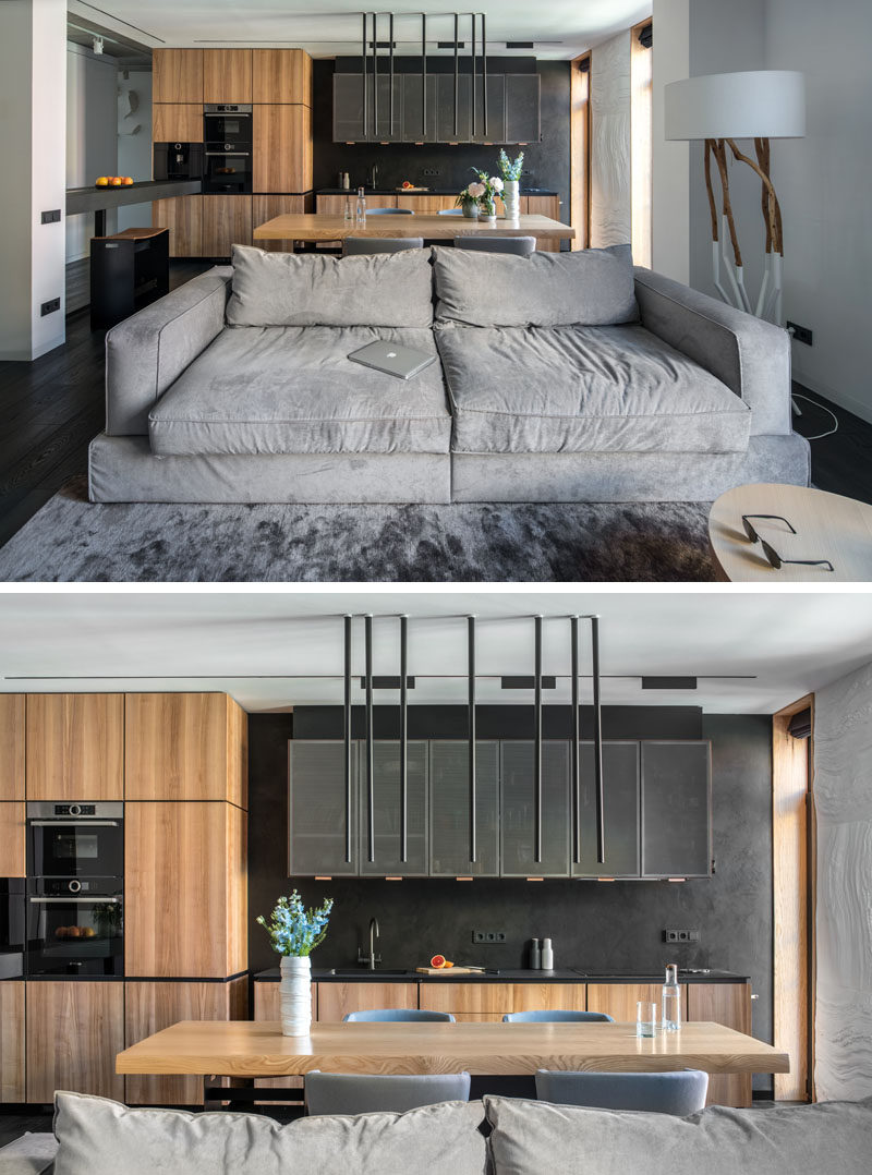 In this modern apartment, the kitchen and the living room were combined into an open space, which is separated by a light grey couch. #ModernKitchen #ModernApartment #ModernInteriorDesign