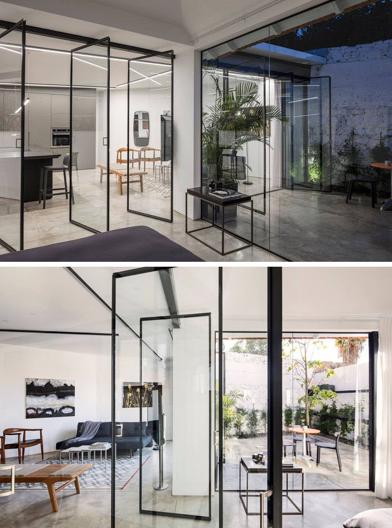 In this renovated home, Belgian style glass pivot windows between the kitchen and the bedroom were installed make the space feel large and open. #Doors #GlassWalls #Windows