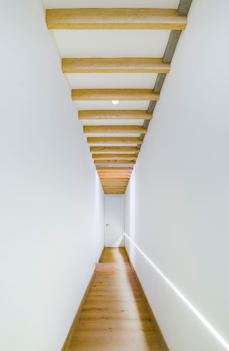 This bright white and wood hallway leads to the bedrooms in a penthouse apartment. #WhiteHallway #WhiteAndWood #InteriorDesign