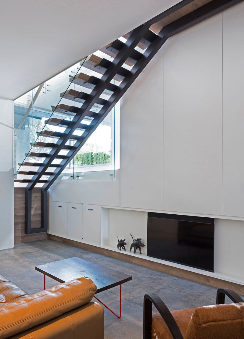 From this basement living room you can see the structure of the open tread wood and steel stairs. #Stairs #Staircase #ModernStairs