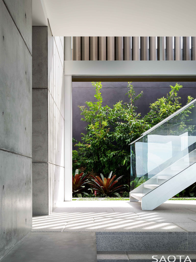 Stairs with glass handrails connect the various levels of the various levels of this modern house. #Stairs #InteriorDesign #Concrete