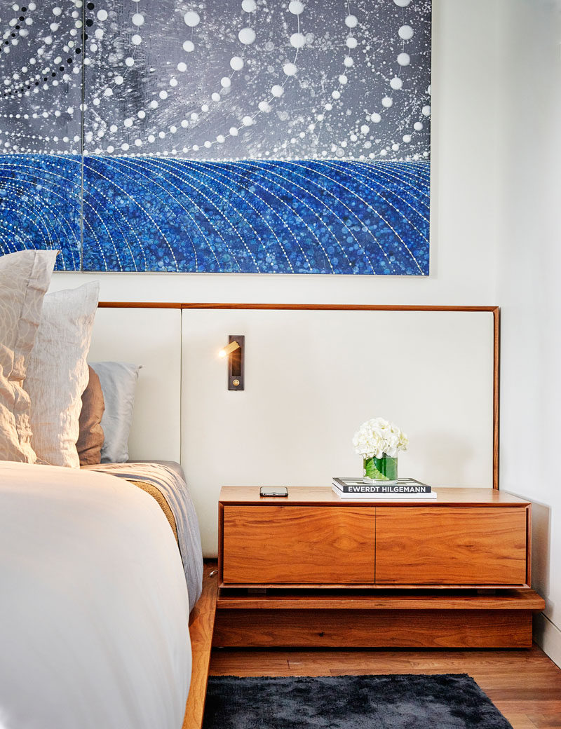 In this modern master bedroom, wood bedside tables are included as part of the wood bed frame. #MasterBedroom #BedroomDesign